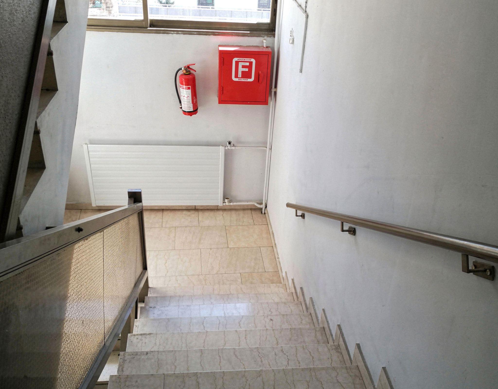 Stairwell with handrail and emergency equipment on the wall, Piraeus, Greece