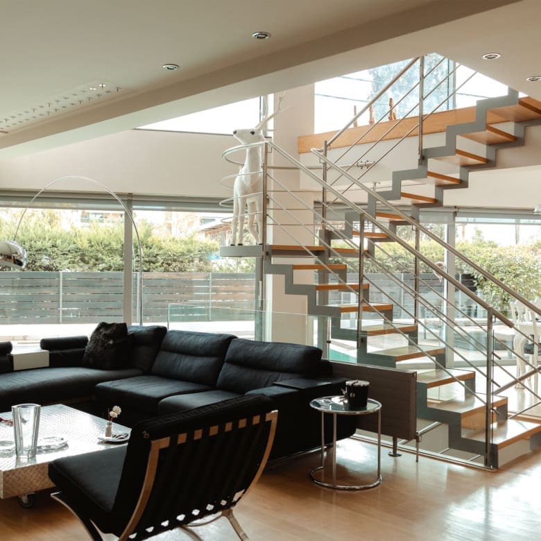Contemporary living room with open layout and staircase at a private villa in Alimos, Athens Riviera