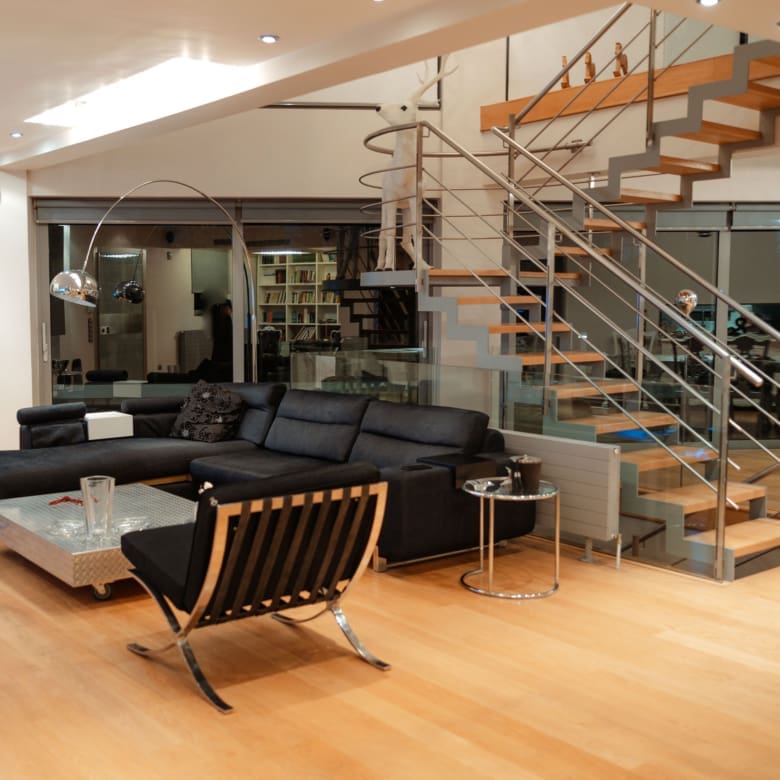 Living area with modern seating and staircase at a private villa in Alimos, Athens Riviera