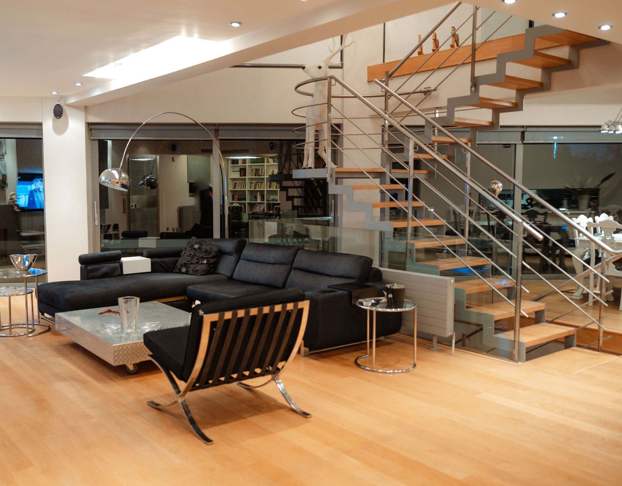 Living area with modern seating and staircase at a private villa in Alimos, Athens Riviera