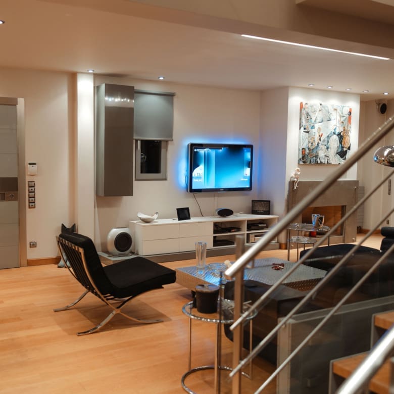 Lounge and TV area with staircase connection at a private villa in Alimos, Athens Riviera