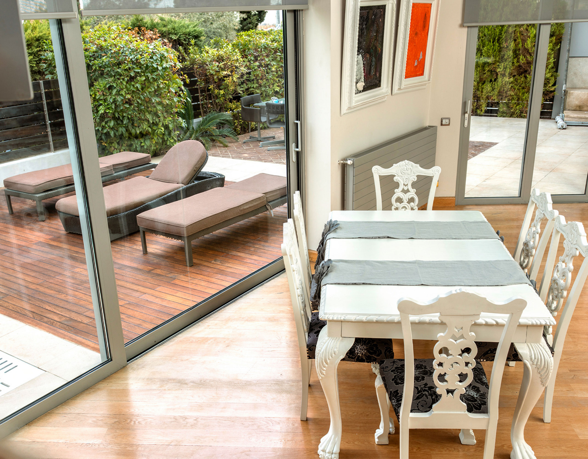 Dining area by sliding doors opening to an outdoor lounge at a private villa in Alimos, Athens Riviera