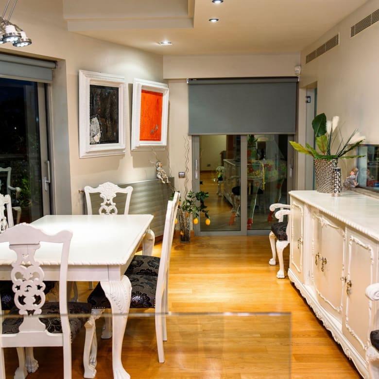 Open-plan kitchen and dining area with sliding doors at a private villa in Alimos, Athens Riviera