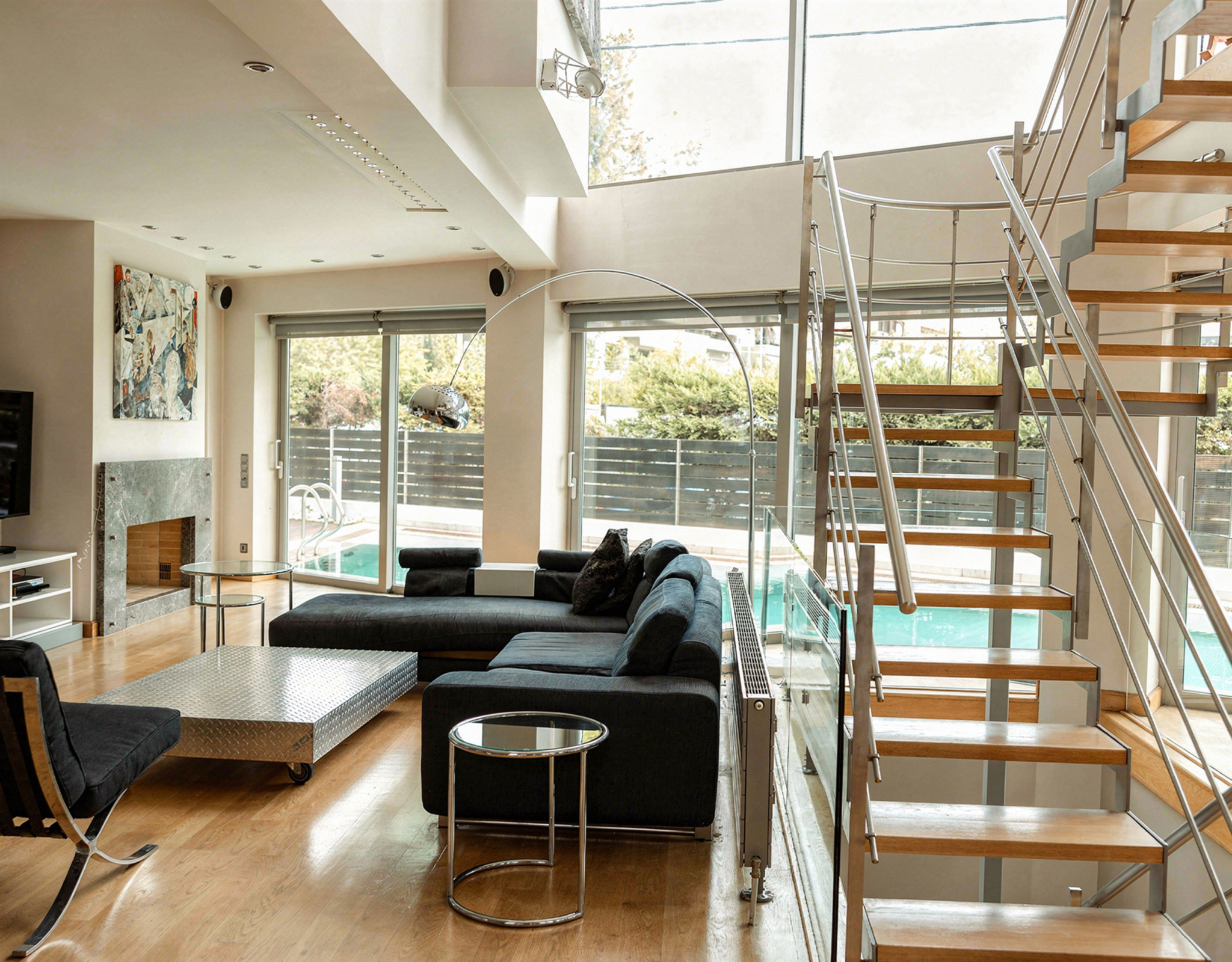 Open-plan living space with staircase and natural light at a private villa in Alimos, Athens Riviera
