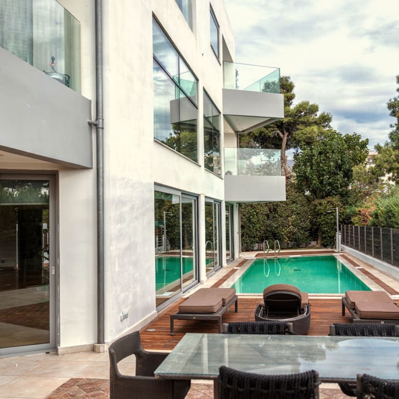 Private pool area with modern villa façade in Alimos, Athens Riviera