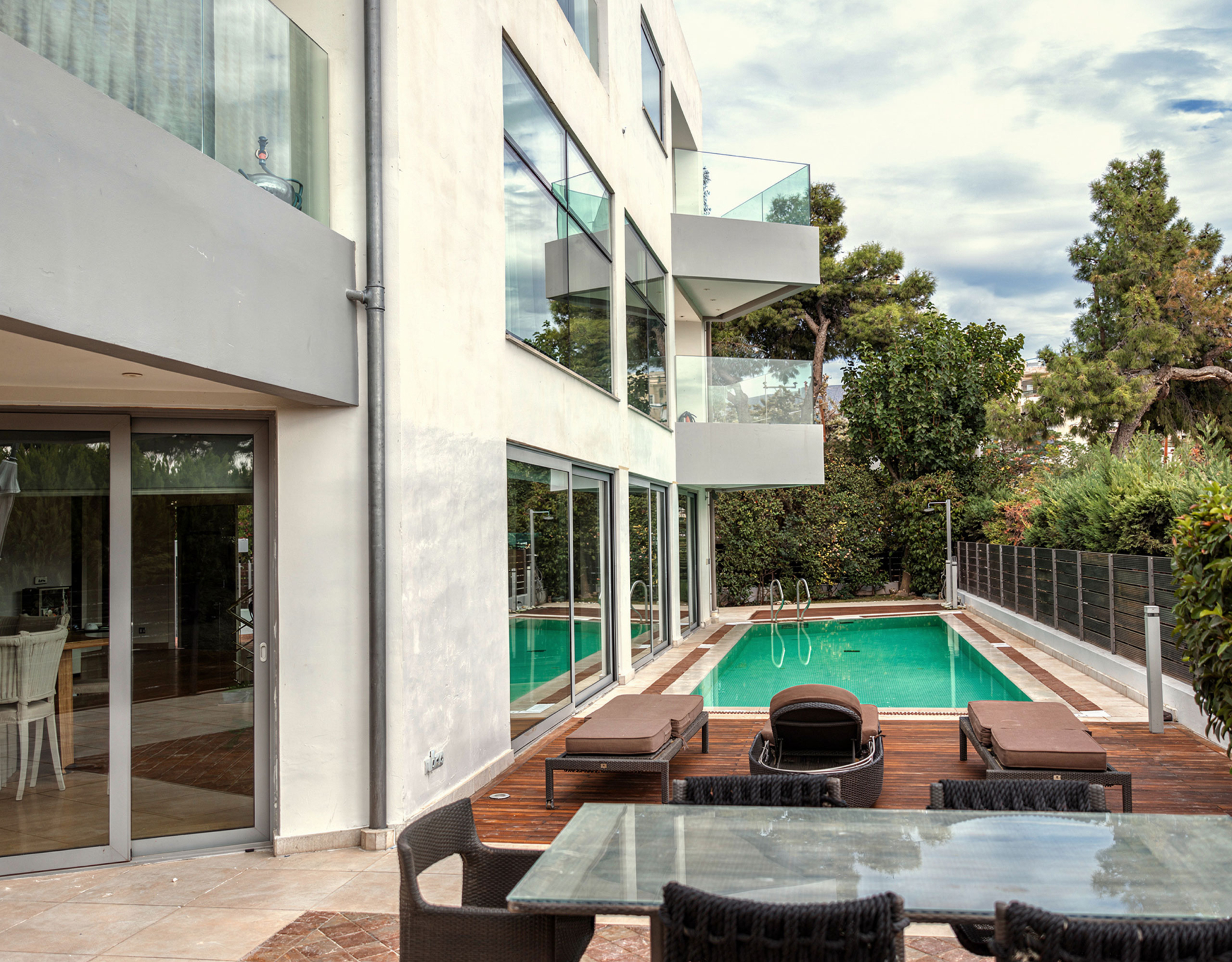 Private pool area with modern villa façade in Alimos, Athens Riviera