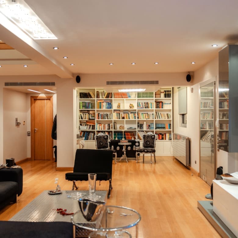 Living area with library wall and open-plan layout at a private villa in Alimos, Athens Riviera