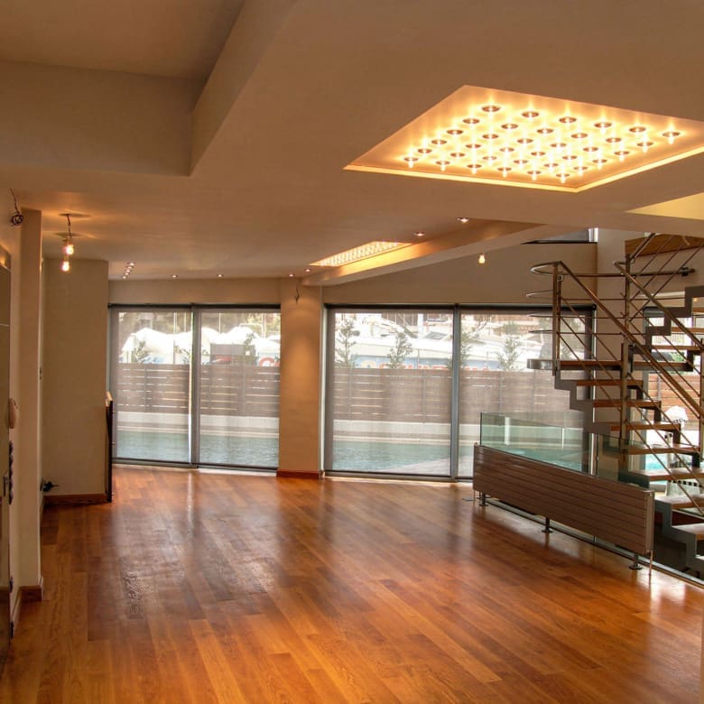 Open interior room with wood flooring and ceiling lighting at a private villa in Alimos, Athens Riviera
