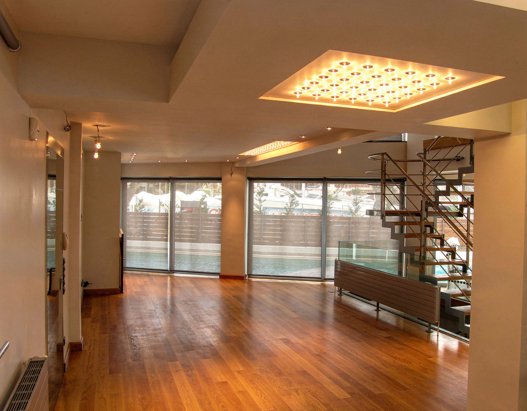 Open interior room with wood flooring and ceiling lighting at a private villa in Alimos, Athens Riviera