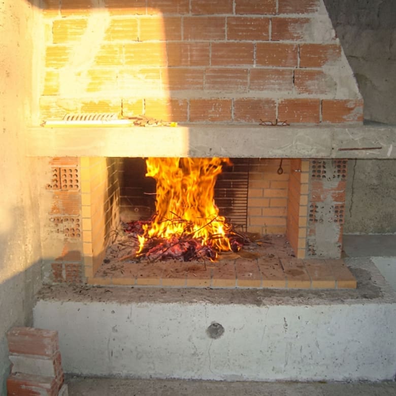 Close-up of a lit fireplace with brick surround, Dilesi, Boeotia, Greece