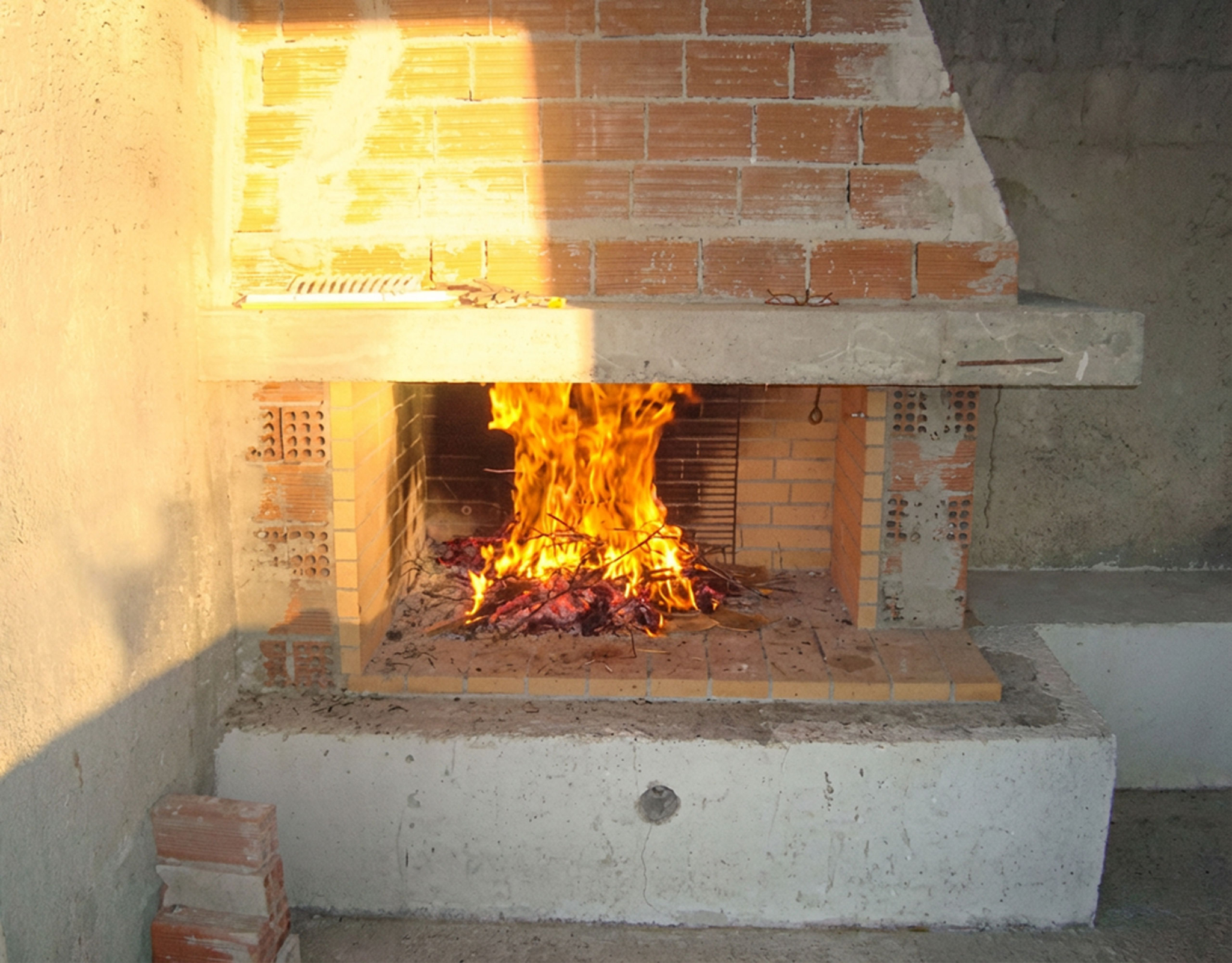 Close-up of a lit fireplace with brick surround, Dilesi, Boeotia, Greece