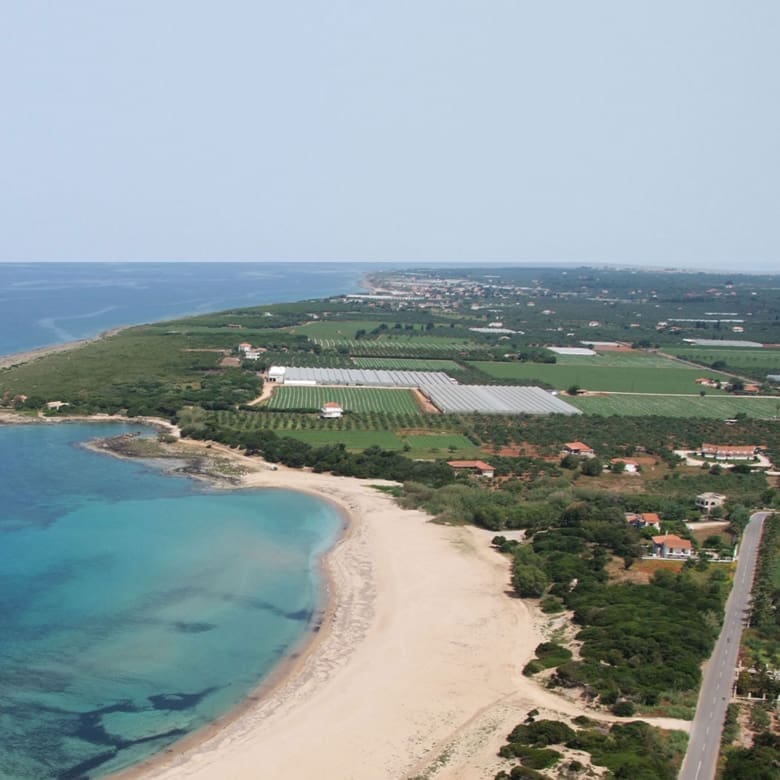 Aerial view of long sandy coastline with turquoise sea and surrounding landscape, Messinia, Peloponnese, Greece