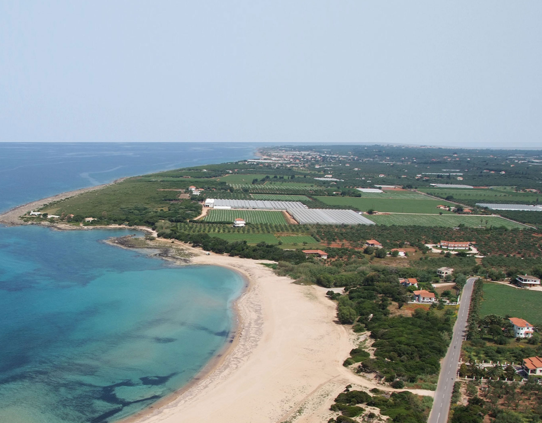 Aerial view of long sandy coastline with turquoise sea and surrounding landscape, Messinia, Peloponnese, Greece
