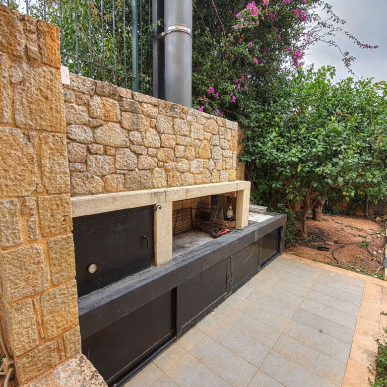 Outdoor built-in barbecue area with stone cladding and counter space, Porto Rafti, Greece