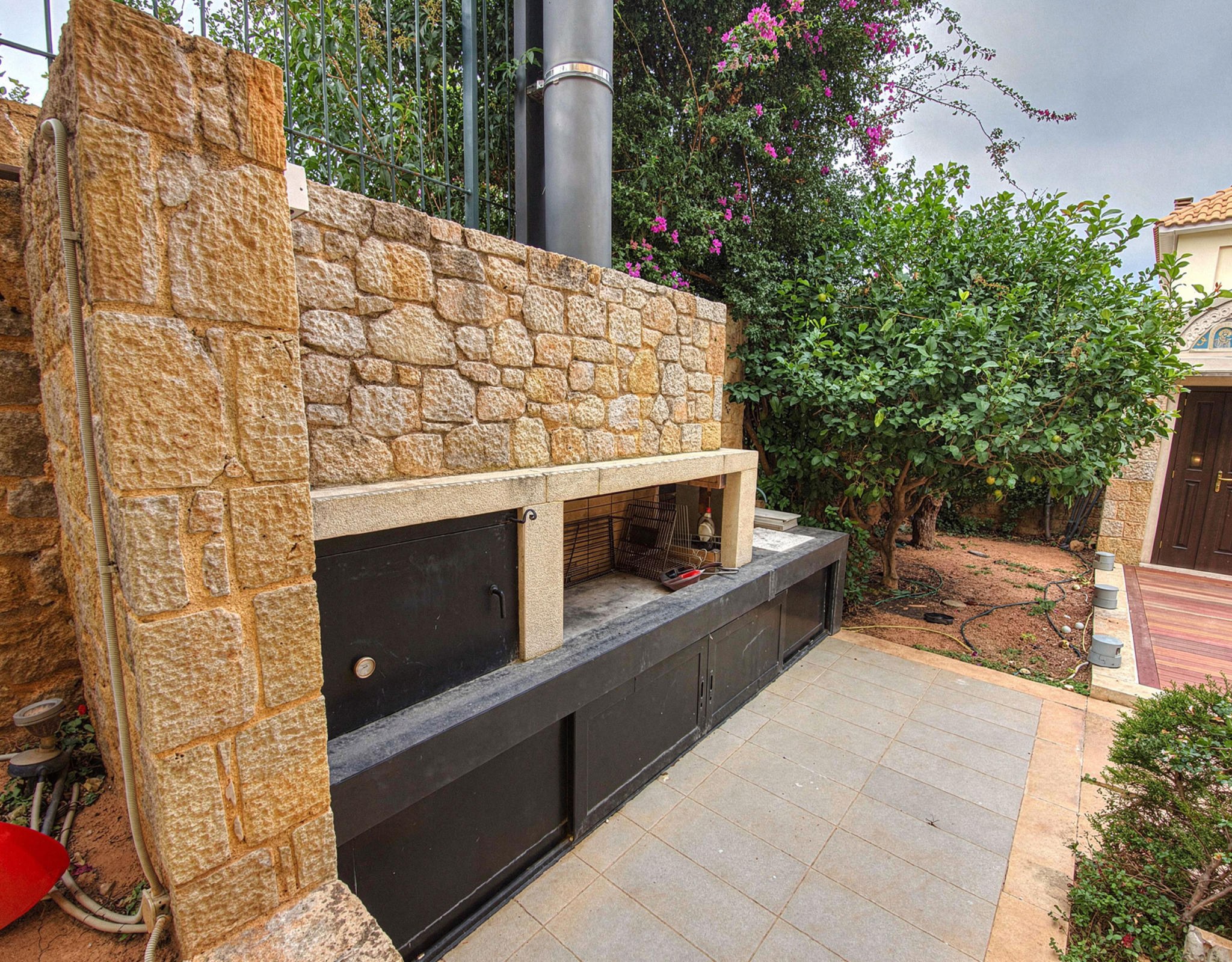 Outdoor built-in barbecue area with stone cladding and counter space, Porto Rafti, Greece