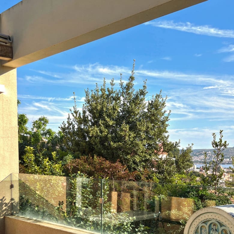 Balcony view with glass railing and greenery, Porto Rafti, Greece
