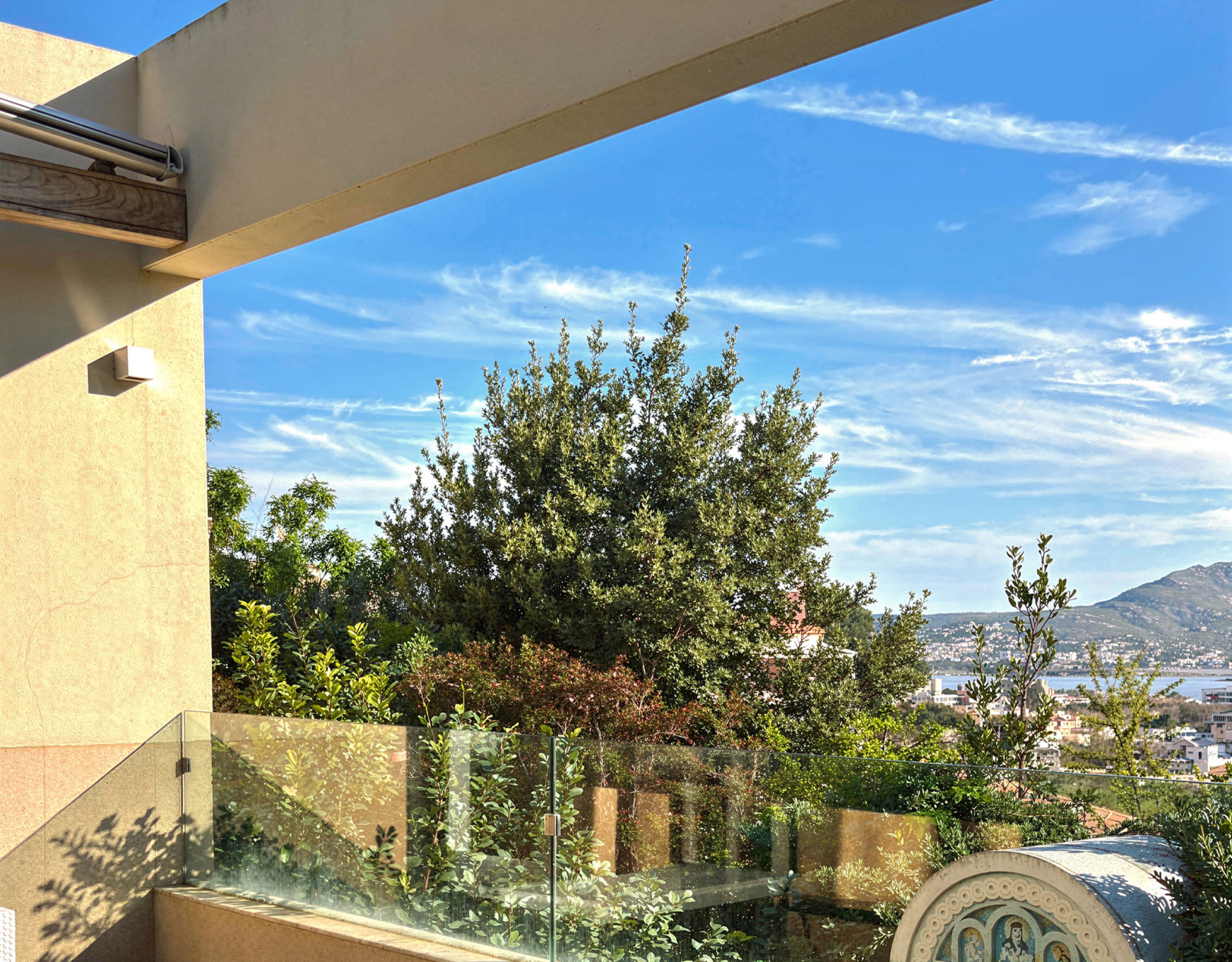 Balcony view with glass railing and greenery, Porto Rafti, Greece