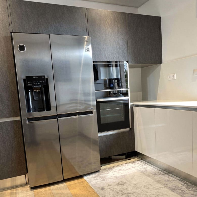 Modern kitchen with stainless steel refrigerator and built-in appliances, Porto Rafti, Greece