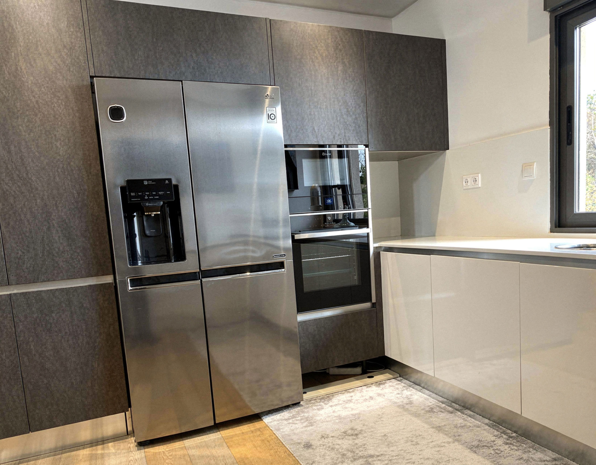 Modern kitchen with stainless steel refrigerator and built-in appliances, Porto Rafti, Greece