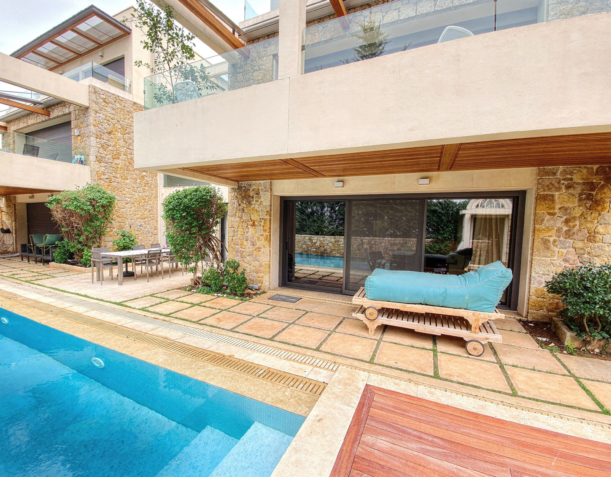 Poolside area with wooden deck, outdoor seating, and covered patio, Porto Rafti, Greece