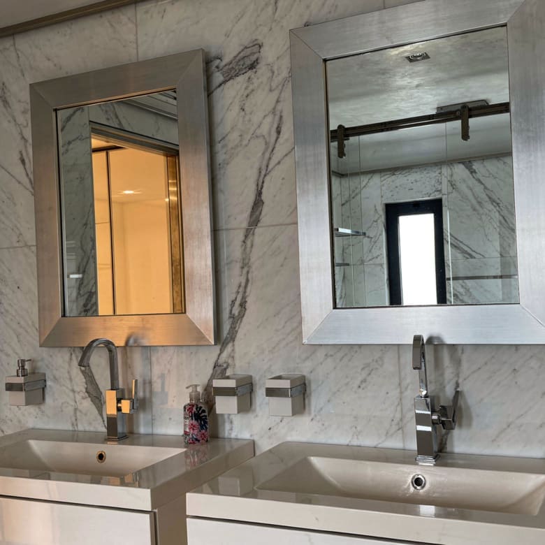 Bathroom vanity with double sink, mirror, and marble-look wall tiles, Porto Rafti, Greece