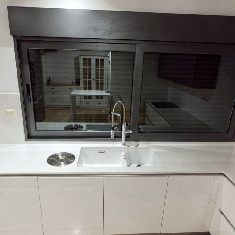 Kitchen sink area with interior window opening and clean modern finishes, Porto Rafti, Greece
