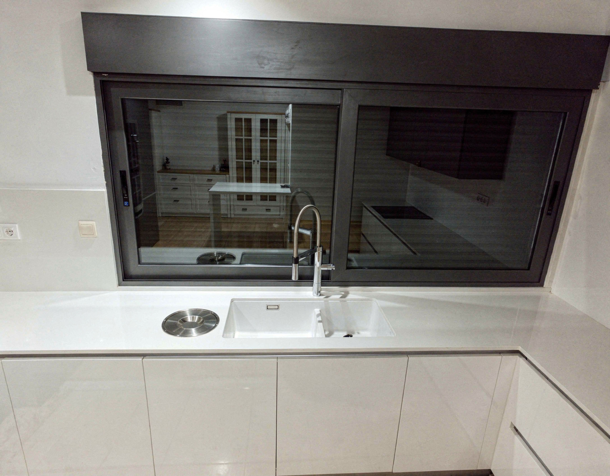 Kitchen sink area with interior window opening and clean modern finishes, Porto Rafti, Greece