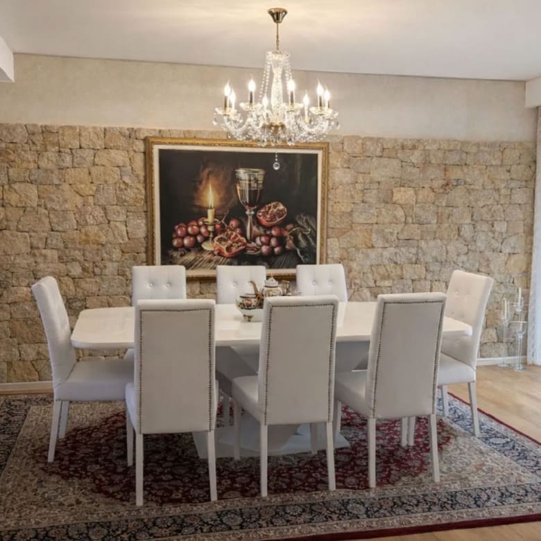 Formal dining room with chandelier, stone accent wall, and dining table, Porto Rafti, Greece