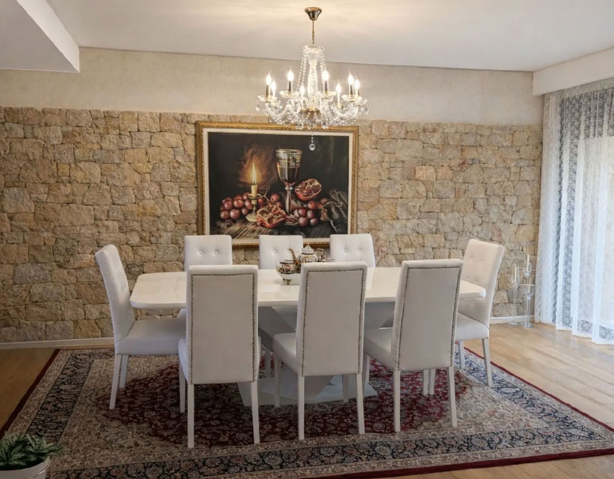 Formal dining room with chandelier, stone accent wall, and dining table, Porto Rafti, Greece
