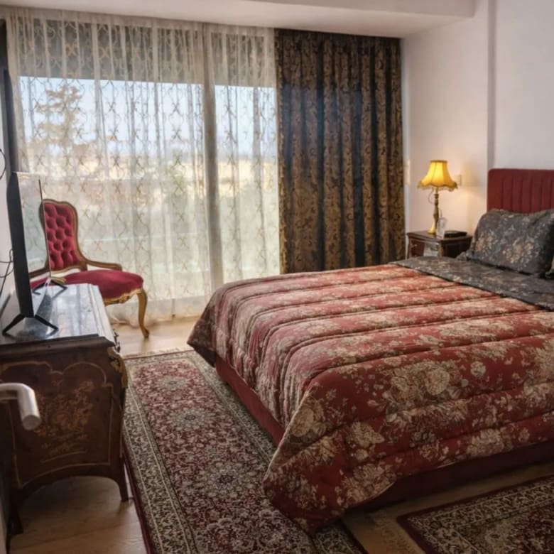 Bedroom with double bed, curtains, and warm interior lighting, Porto Rafti, Greece