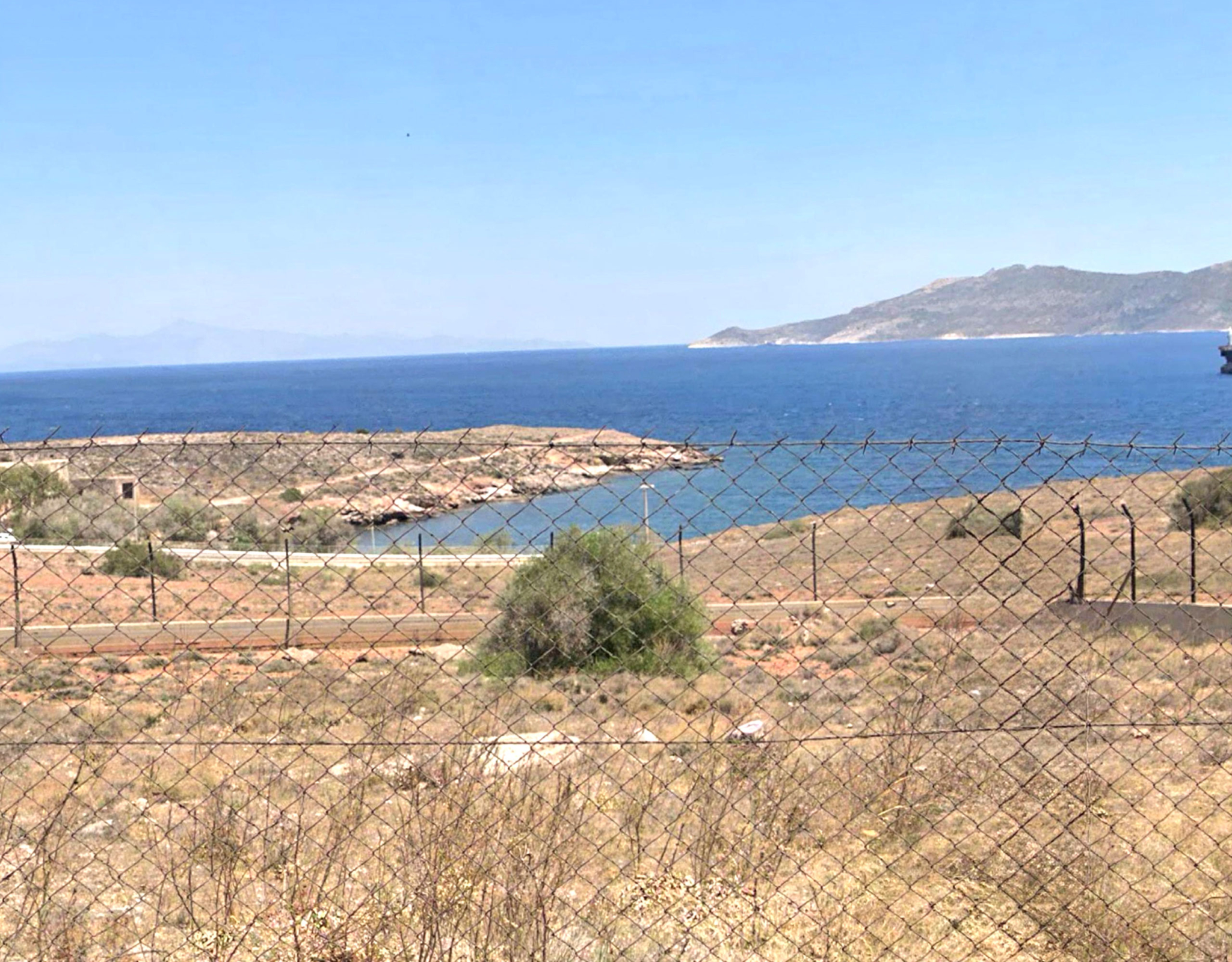 Sea view over dry coastal terrain with distant islands, Greece