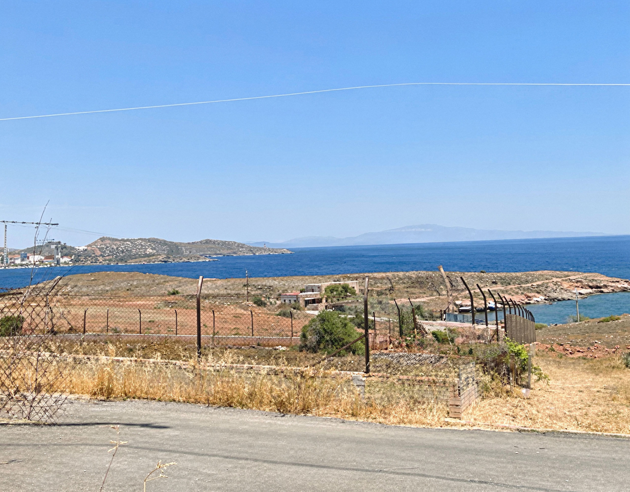 Coastal land view with fencing and sea horizon, Greece
