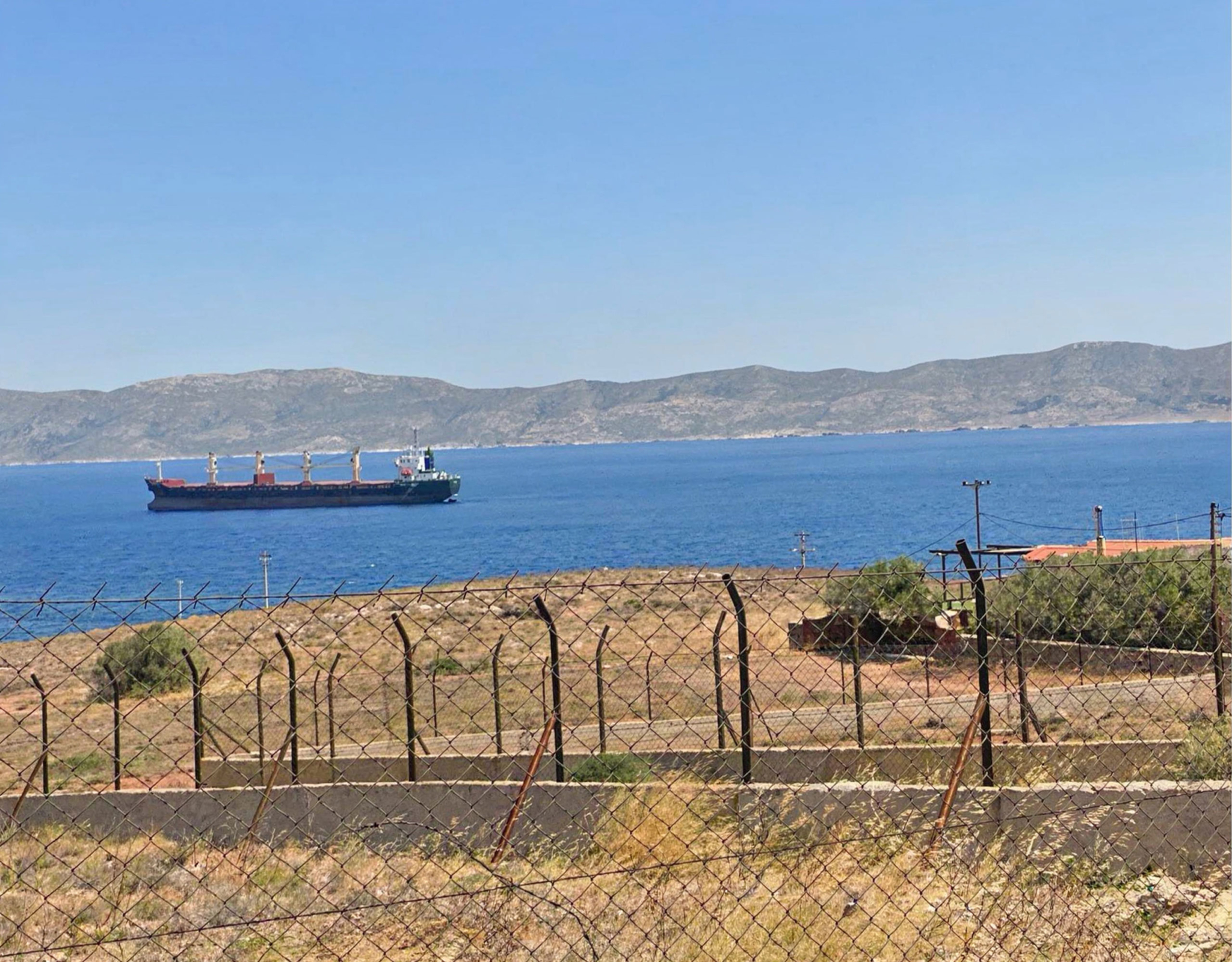 Coastal sea view with passing ship and distant mountains, Greece