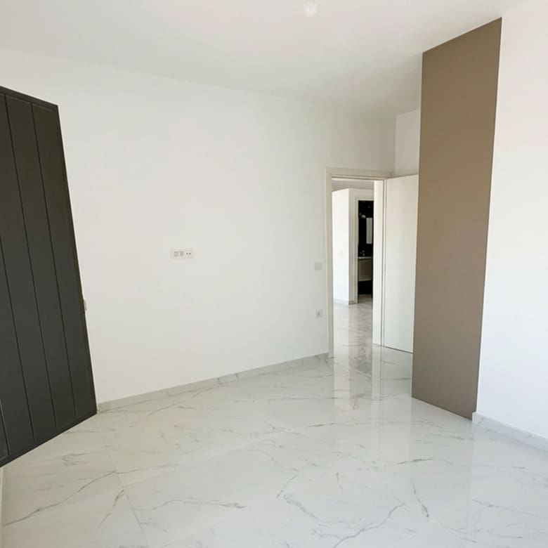 Minimal bedroom interior with built-in wardrobe in the Exo Gonia apartment, Santorini