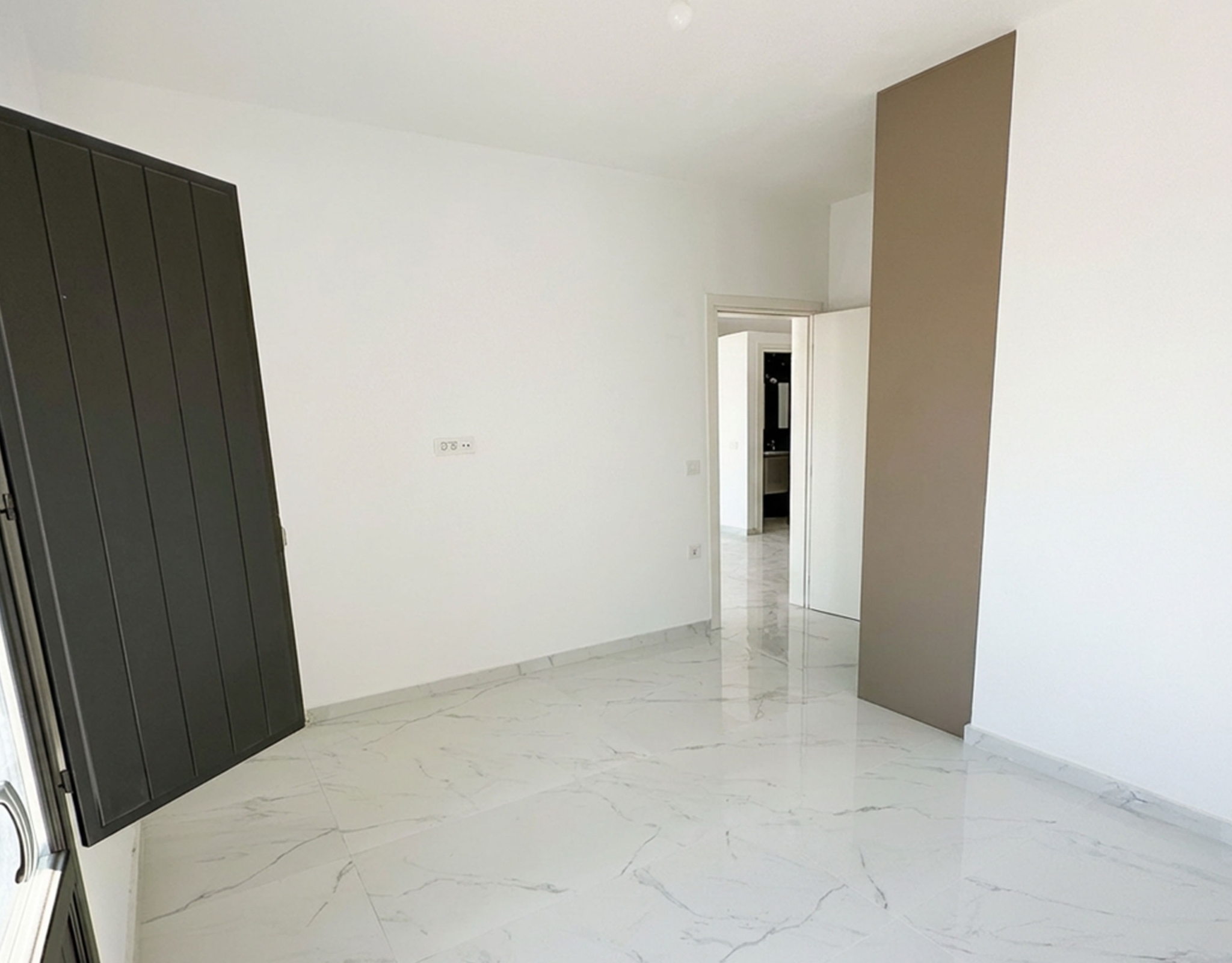 Minimal bedroom interior with built-in wardrobe in the Exo Gonia apartment, Santorini