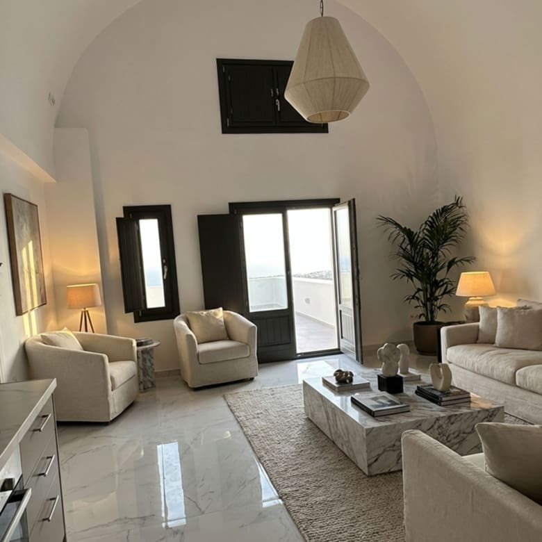 Open-plan living and dining area with Cycladic curves in Exo Gonia apartment, Santorini