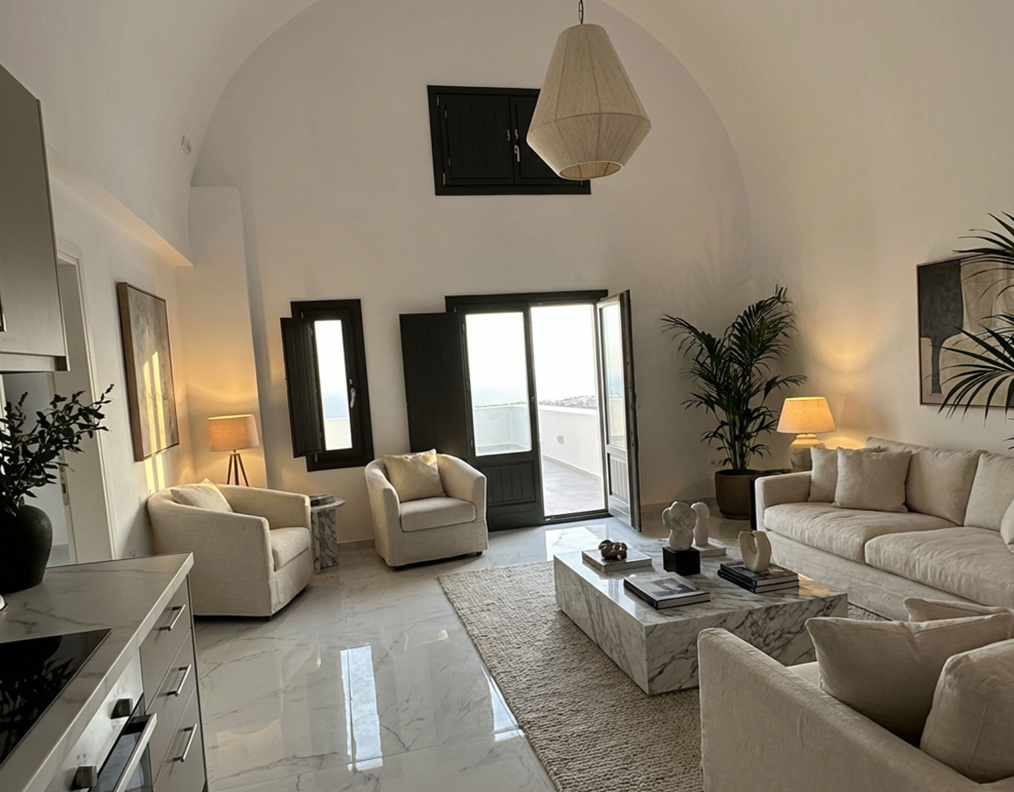 Open-plan living and dining area with Cycladic curves in Exo Gonia apartment, Santorini