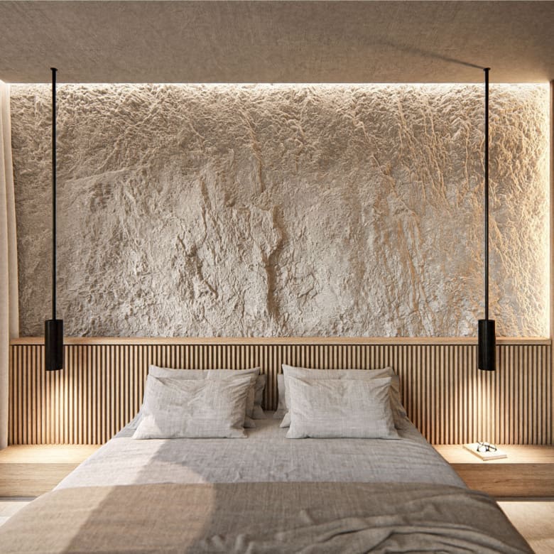 Minimal bedroom with textured wall and warm lighting at The Pebble House, Tinos, Cyclades