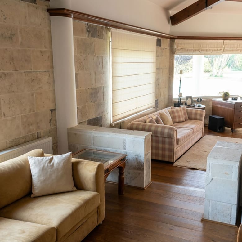 Living area with stone finishes and natural light at a private estate in Porto Rafti, Attica