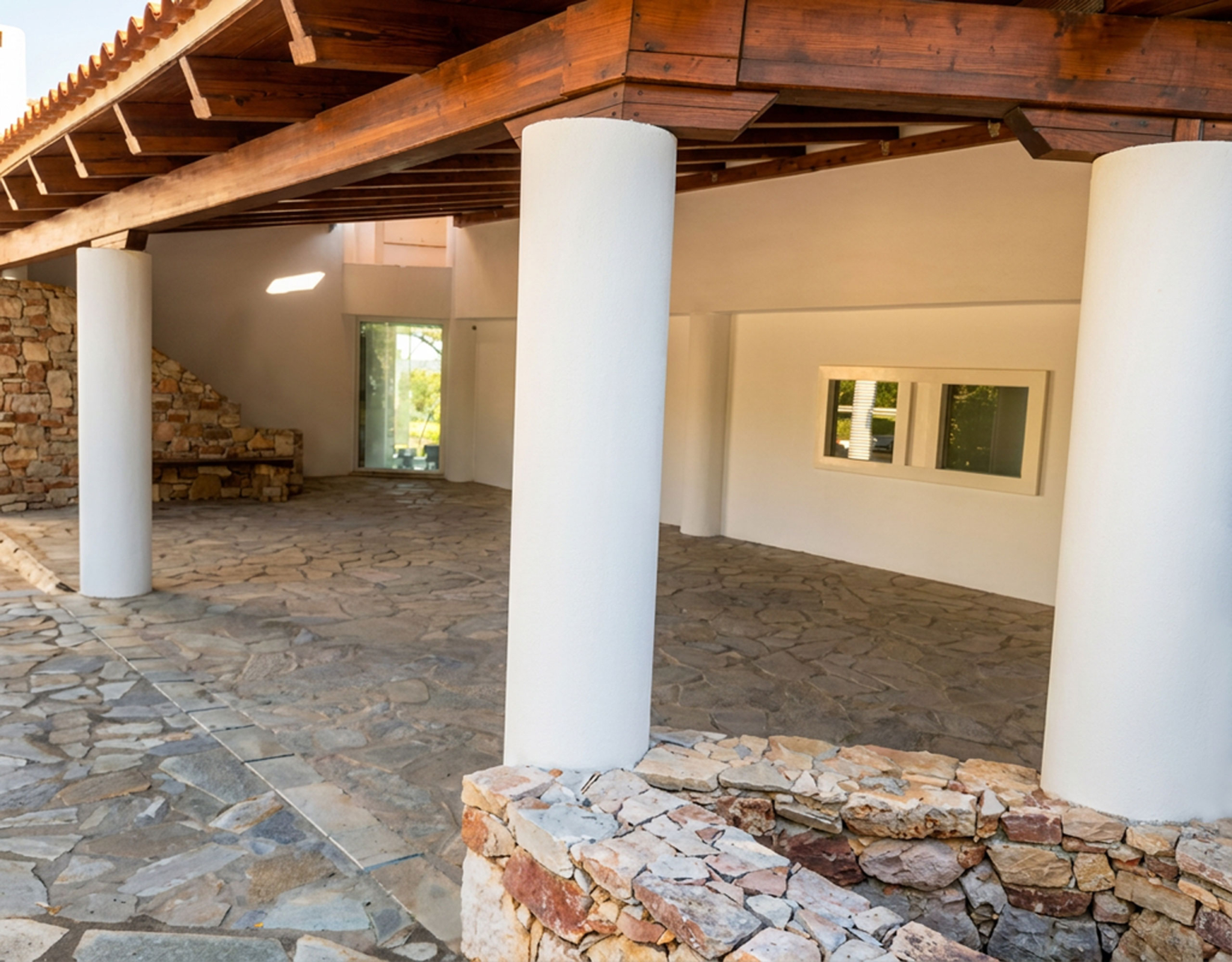 Porto Rafti Estate – Covered Walkway with Columns Covered outdoor walkway with stone flooring and columns at the Porto Rafti private estate