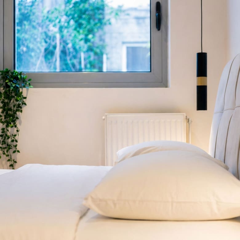 Bedroom detail with upholstered headboard and window view, Nea Filothei, Athens, Greece