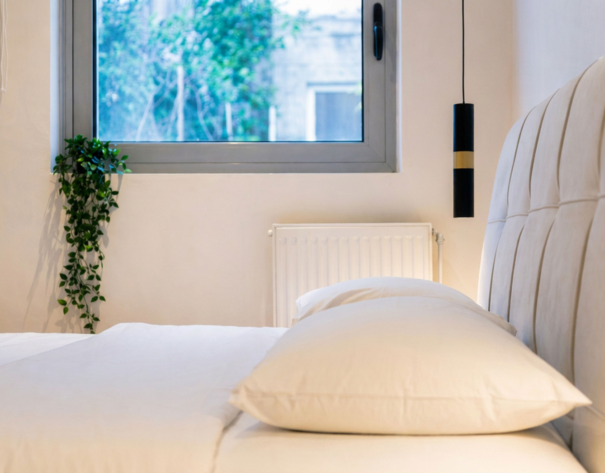 Bedroom detail with upholstered headboard and window view, Nea Filothei, Athens, Greece