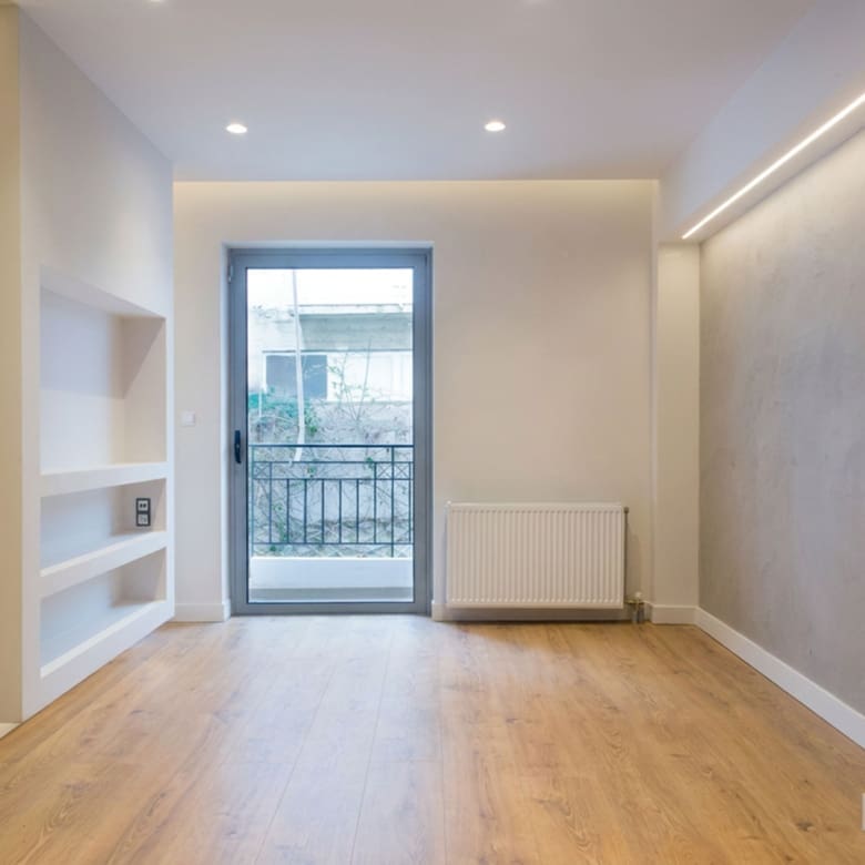 Bright empty room with wood flooring and balcony door, Nea Filothei, Athens, Greece