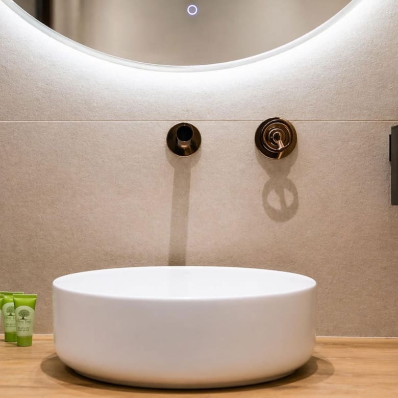 Bathroom basin sink detail with round mirror and soft backlighting, Nea Filothei, Athens, Greece