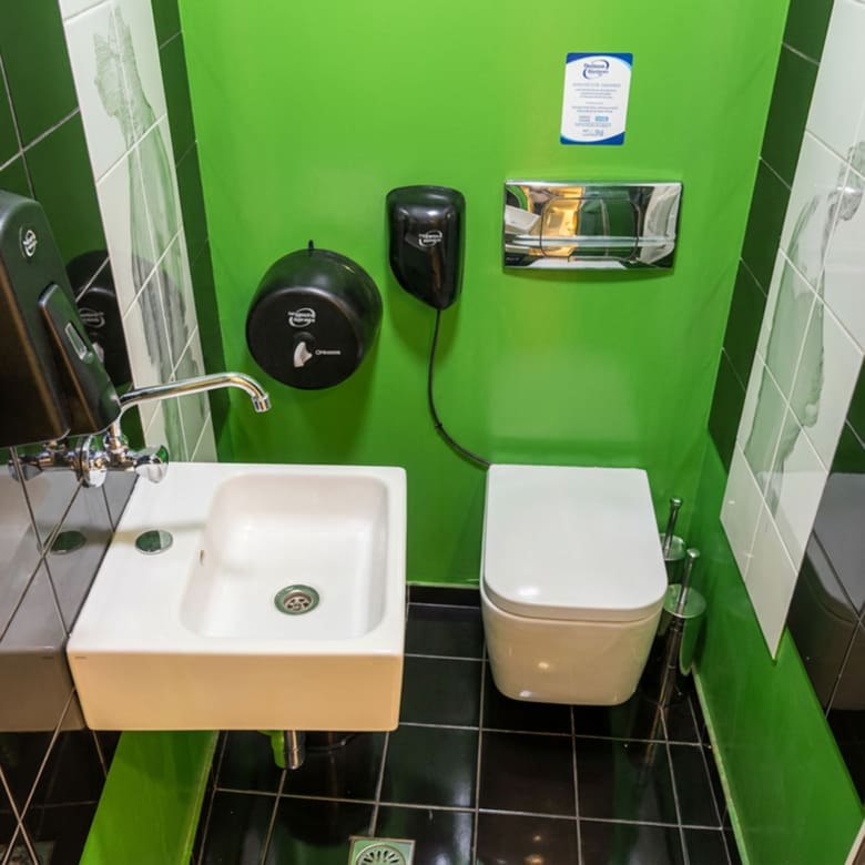 Πλήρως εξοπλισμένο WC με πράσινους τοίχους, νιπτήρα και λεκάνη σε εμπορικό χώρο στο κέντρο Θεσσαλονίκης
