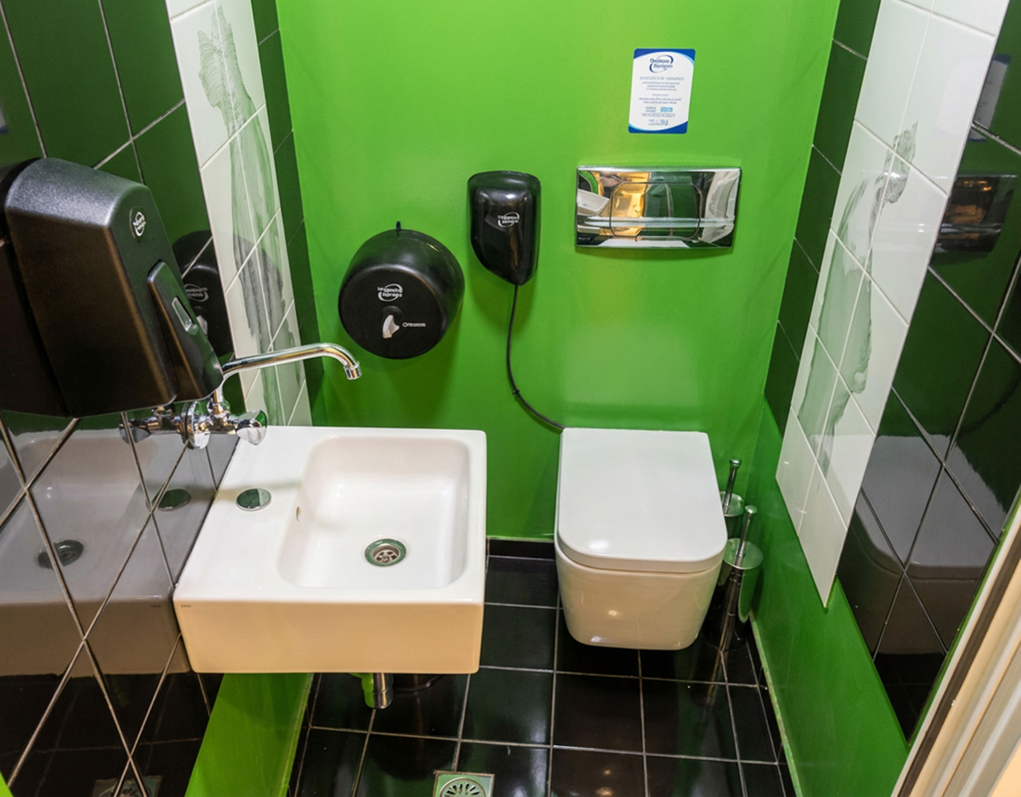 Πλήρως εξοπλισμένο WC με πράσινους τοίχους, νιπτήρα και λεκάνη σε εμπορικό χώρο στο κέντρο Θεσσαλονίκης
