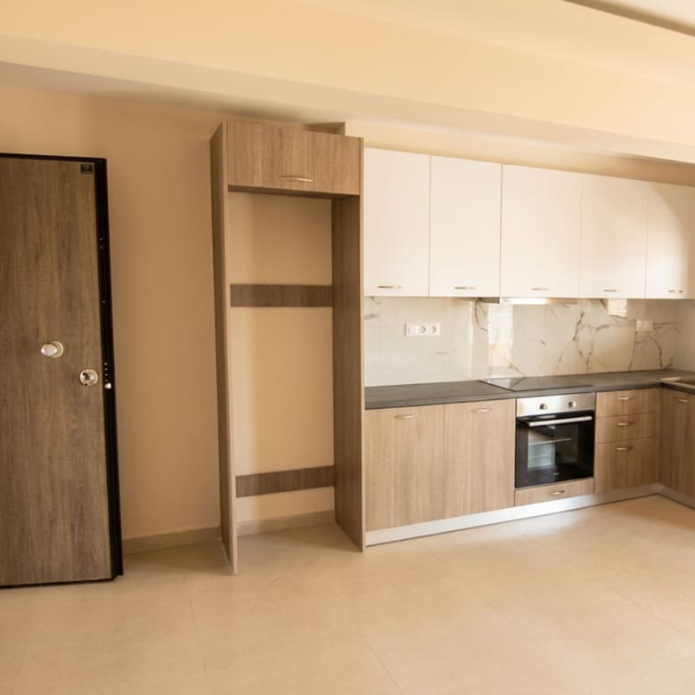 Modern fitted kitchen with built-in oven and security entrance door in a newly built duplex maisonette in Nea Ionia, Volos