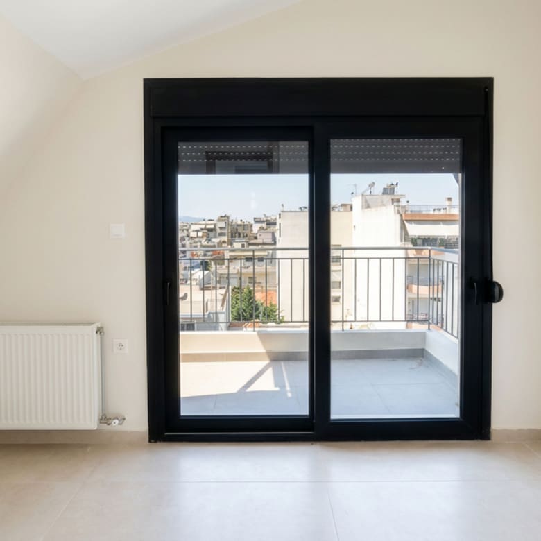 Bright room with balcony doors and city view in a newly built duplex maisonette in Nea Ionia, Volos