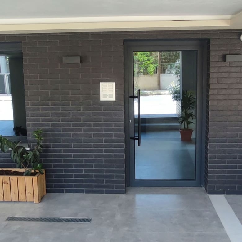 Modern building entrance with secure glass door and contemporary facade