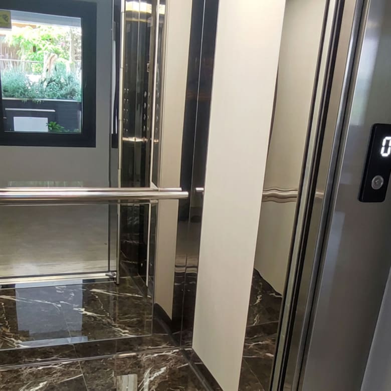 Modern elevator cabin with stainless steel details in a newly built residential building